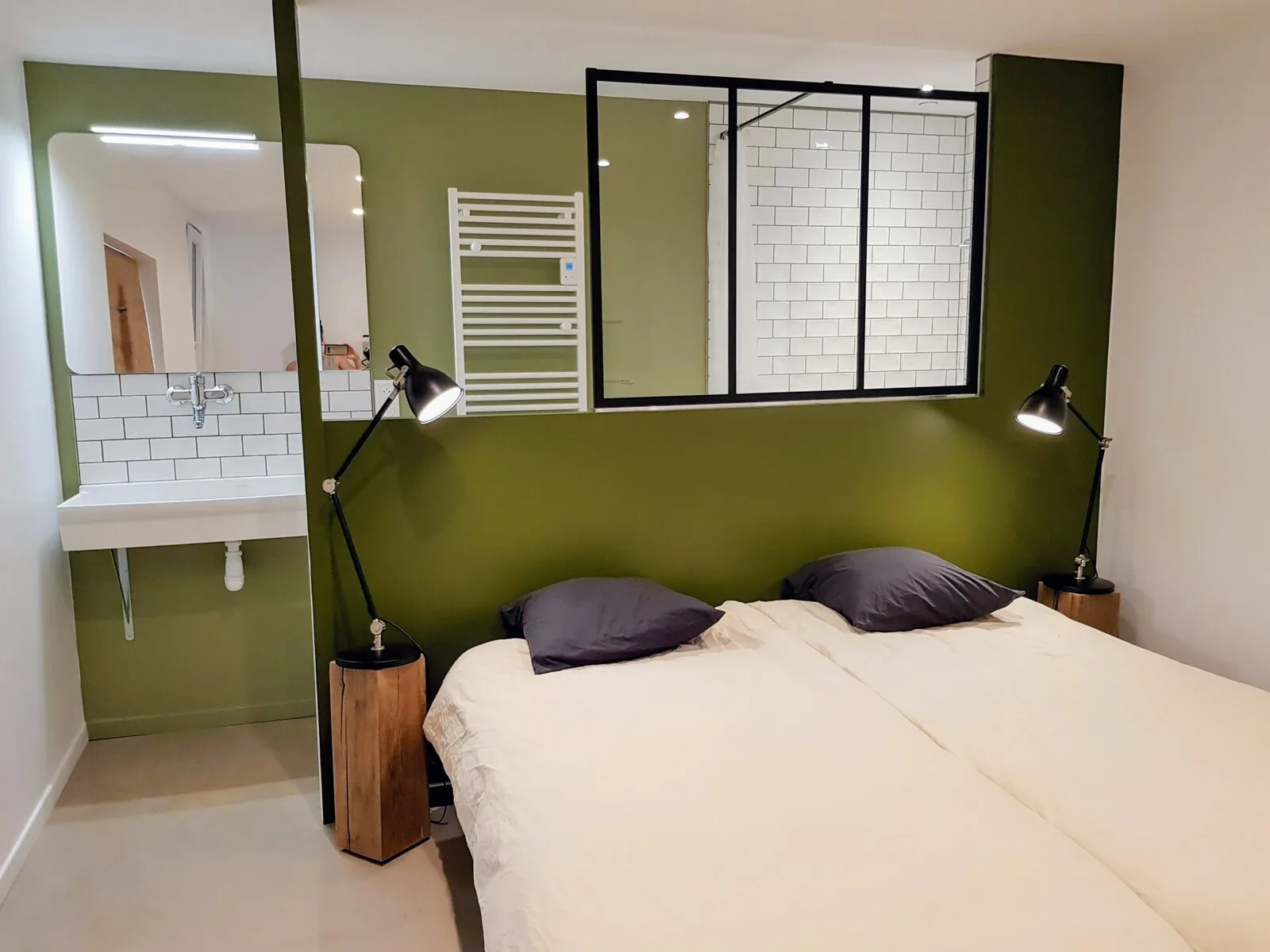 Chambre avec lit queen size et verrière sur la salle de douche