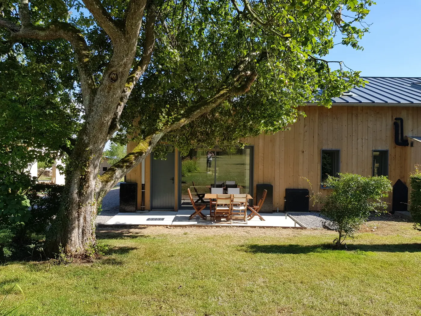 Le Swing, façade bois et terrasse privative sous le vieux pommier